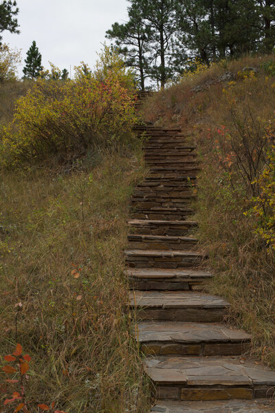 Stairs climb up the hillside away from the natural entrance.