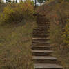 Stairs climb up the hillside away from the natural entrance.