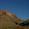 The Chisos Mountains, rock walls and moon from the Ward Spring Trail at sunset.