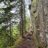 View up the trail along a large steep wall of rock