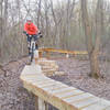 Raised bridge skinny in the optional X section; the rock steps to the left of my front wheel provide an optional easier exit; west loop, Carver Lake MTB trail