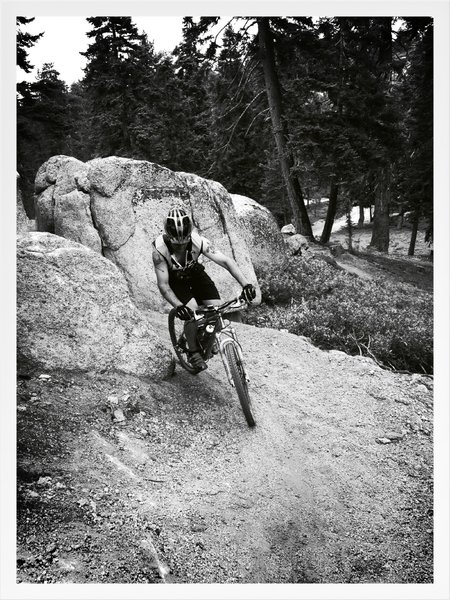 Adam B. is exiting a split boulder formation. One of the handful through-boulder routs this trail has!
