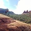 A rider rolls down Submarine Rock to gorgeous views of Twin Buttes.